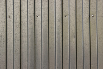 Texture of zinc covered wave-shaped steel sheet with screws in it