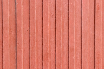 Texture of an old wave-shaped metal sheet painted in red