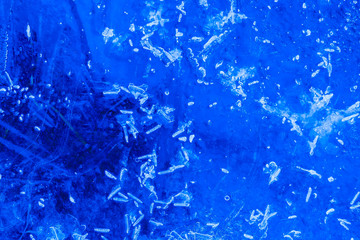 blue texture of an ice surface with pure azure water ,cold snow cryslallized wall background ,winter frozen lake side close up , abstract macro wallpaper