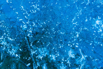 blue texture of an ice surface with pure azure water ,cold snow cryslallized wall background ,winter frozen lake side close up , abstract macro wallpaper