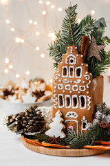 Delicious homemade baked gingerbread house with white icing. Rustic style, dark wooden background,...