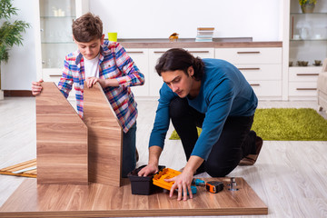 Young carpenter teaching his son