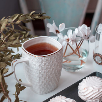 Black tea with flowers, sweets and plants