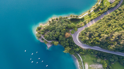 Earth's line. A vertical perspective of the ground's colors and shapes. Drone aerial view of the lake Ledro. A natural alpine lake. Amazing turquoise, green and blue natural colors. Italian Alps
