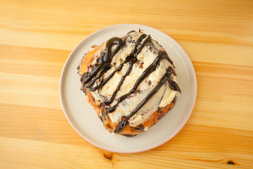 roll with cinnamon on a plate on  wooden background