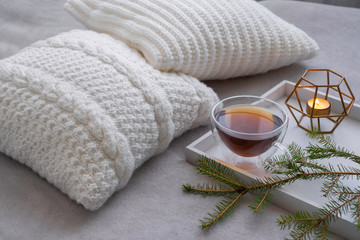 Composition of white knitted pillows with tea