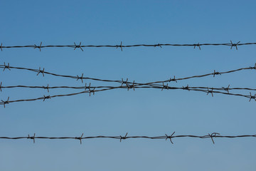 Barbed wire. Clear blue sky as background. Protection, security concept.