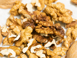 Slide peeled walnuts closeup. Table made of artificial stone.