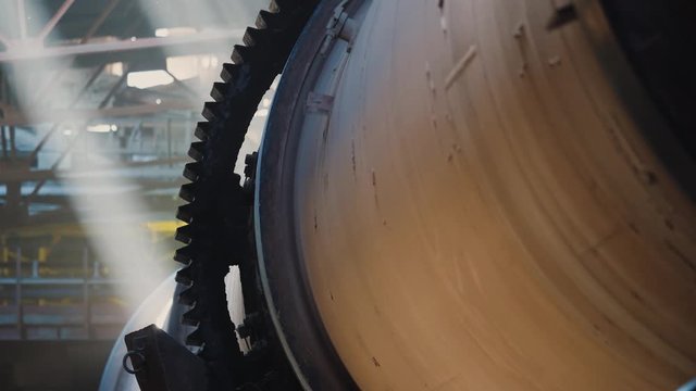 Gears of rotation of a cylindrical furnace. Rotary burning kiln on a cement plant. Industrial production process of cement clinker or expanded clay. Huge industrial oven on a factory.