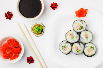 Funny edible Christmas tree, from sushi rolls, on white background. Creative idea for japanese restaurant. The concept of food for the new year and christmas. Top view. Copy space.