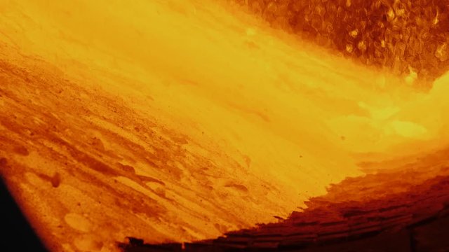 Industrial production process of expanded clay. Oven rotates and glowing hot expanded clay tumble and flow inside of rotary burning kiln.