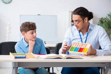 Obraz premium Young father helping his son to prepare for exam