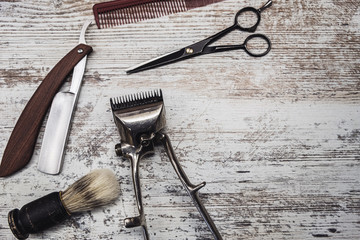 vintage barber tools dangerous razor hairdressing scissors old manual clipper comb shaving brush. old white weathered wood background.