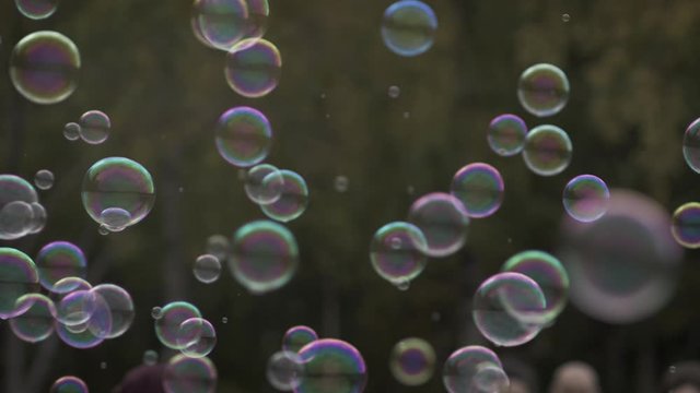Small bubbles floating around with people passing in the background