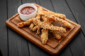 Fried crispy chicken nuggets with ketchup on white board