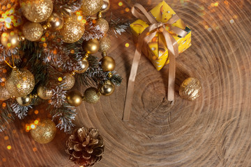 Christmas or New Year composition. Christmas tree with festive decor on a wooden table with golden bokeh. Holiday and celebration concept for greeting card or invitation. Top view. Copy space