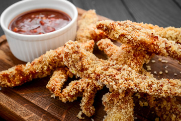 Fried crispy chicken nuggets with ketchup on white board
