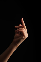 Human hand sign showing middle finger. Hand sign showing middle finger in rude way meaning fuck off, isolated on black background. 