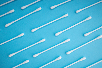 Hygiene cotton sticks. Skincare mockup for design. Stack of disposable cotton stick on a blue background. Cosmetology concept.