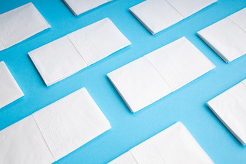  White hygiene napkins on a blue background. Skincare mockup for design. Stack of disposable...