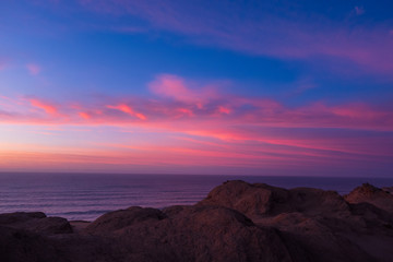 Fototapeta na wymiar Sonnenuntergang am Meer vor bizarrer Felsküste