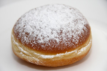 Fresh homemade Austrian Carnival Donut so called Faschingskrapfen or Berliner, sweet Krapfen filled with apricot jam and icing sugar close up on white Background 