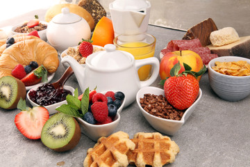 Breakfast served with coffee, orange juice, croissants, cereals and fruits. Balanced diet. Continental breakfast with granola and fruits