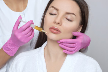 Cosmetologist does prp therapy anti wrinkle and aging skin on the chin and on the face of a...