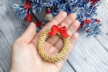 A small Christmas wreath of straw in the palm of your hand..Handmade Christmas decoration made of natural materials.