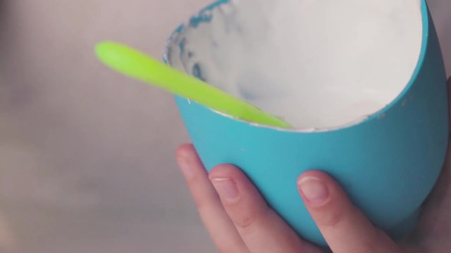 Mixing and making white fluffy slime in a blue container