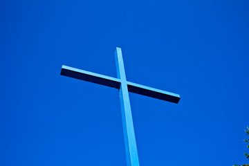 A blue cross of a church towards the blue sky in Bavaria, Germany