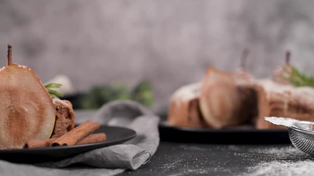 Delicious cake slice with pear, ginger and cinnamon on a plate in a dark kitchen counter.