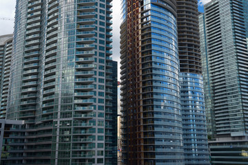 Crowded highrise condominium construction in Toronto with bank towers seen through a slit