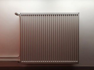 Convection radiator, or radiant space heater with steel body and rotary control regulator for energy saving. Home and office engineering equipment of central heating system depicted in warm shades.