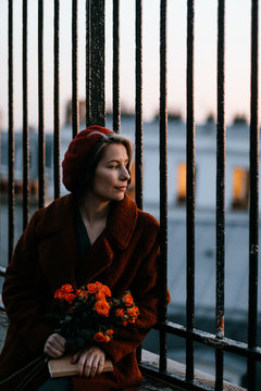 romantic Parisian woman looking through some railings