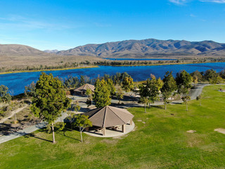 Aerial view of little park in front of Otay Lake City Reservoir with blue sky and mountain on the background, Chula Vista, California. USA - obrazy, fototapety, plakaty