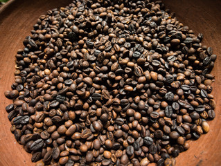 Roasted coffee beans on a clay bowl