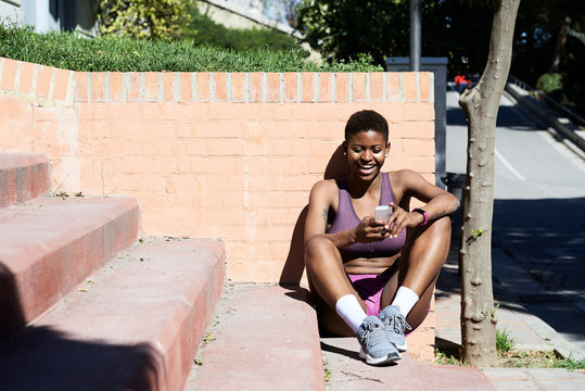Black afro sportswoman smartphone.