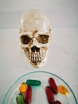 skull and crossbones and​ dengerous drug pill capsule