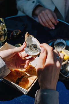 Crop woman eating oyster in restaurant