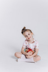 Close up portrait of little cute adorable girl posing alone on isolated white background in studio. Childhood, fashion kids, baby model concept