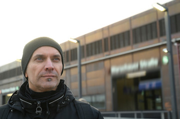 Man looking at something. Blurred train station in the background. Berlin, Germany.