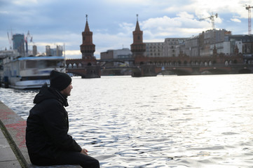 Man sitting close to the river in Berlin, Germany. Winter time.