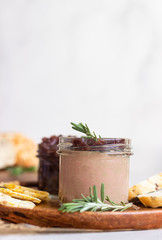 Fresh homemade chicken liver pate and onion chutney (marmalade) in a jar, bread and crackers on a...