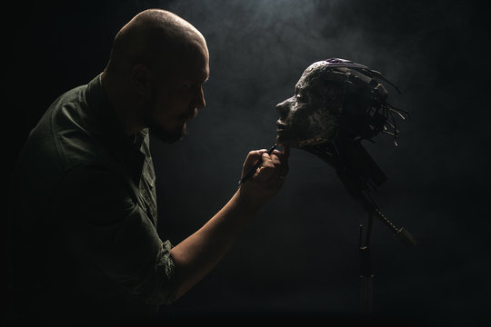 Man holding ornamental metal skull