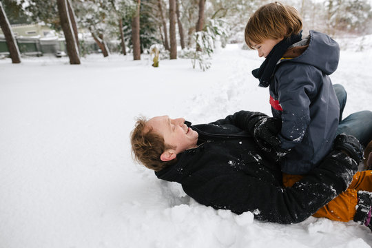 Young family having fun playing togther in the snow.