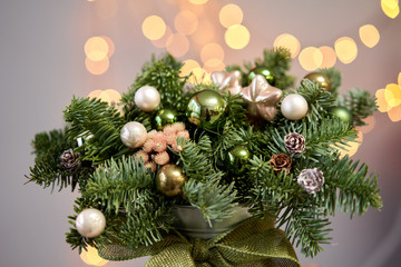 Two Small arrangements of fresh spruce in a metal pot. Christmas mood. Bokeh of Garland lights on background.