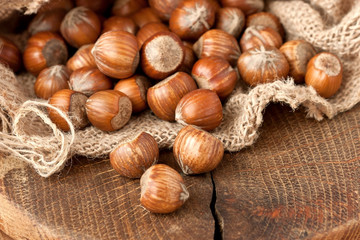 Burlap with hazelnuts on  wooden  background, selective focus