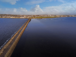 Obraz premium Causeway from Mutton island to Galway city, Atlantic ocean, Sunny day, Aerial view, Cloudy sky.