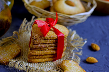 Cookies heart. Handmade cookies made of almond flour tied with a red ribbon close-up on a dark background.Concept of festive baking for Valentine's Day, mother's day, birthday